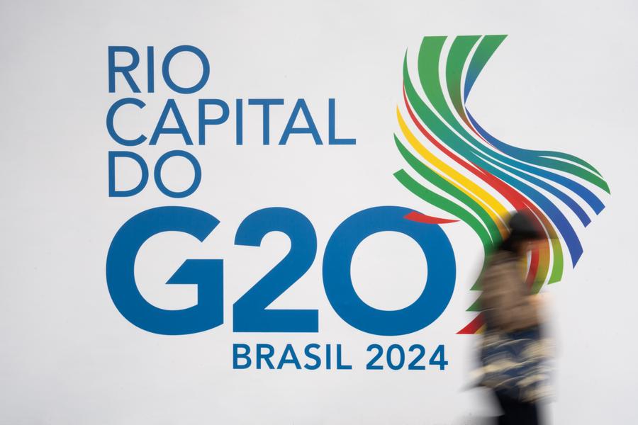 Una mujer camina junto a un logotipo del G20 cerca de la sede principal de la 19a Cumbre del G20 en Río de Janeiro, Brasil, el 16 de noviembre de 2024. (Xinhua/Wang Tiancong)